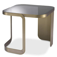Side Table Numa, shown in brushed antique brass and smoked gray with metal, glass, and fixed asymmetric base.