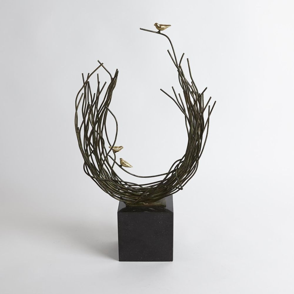 Bird's Nest, shown in dark bronze-green and black with metal, stone, and a freestanding cubic stone base.