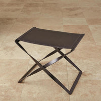 Folding Stool, shown in dark brown and espresso with leather, metal, and a folding x-frame base.