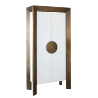 Framed Tall Cabinet, shown in white and antique brass with metal, wood, and double doors with centered circular pull.