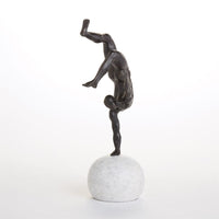 Additional view of One Hand Balancing Act in dark bronze and white, featuring honed finish and a spherical freestanding base.