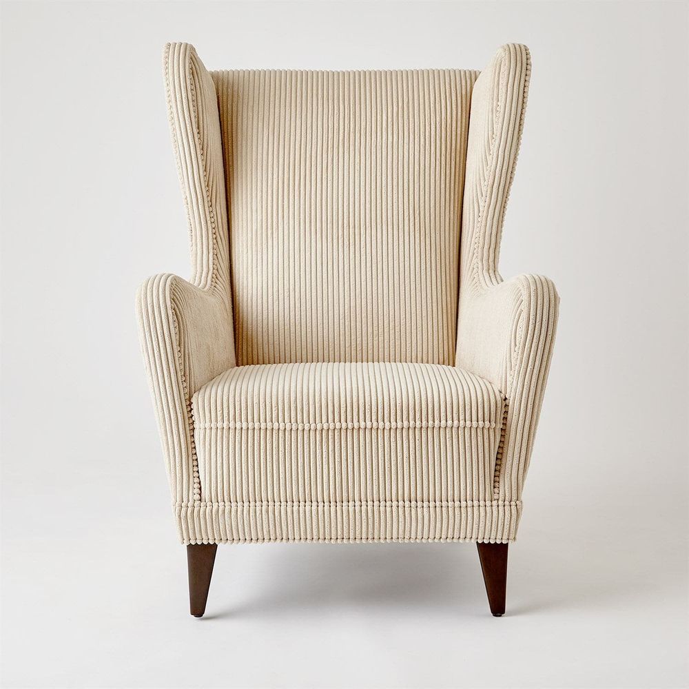 Wing Chair, shown in cream and ivory with corduroy fabric, wood, and fixed arms.