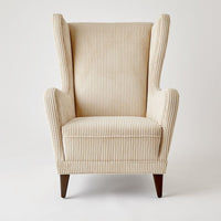 Wing Chair, shown in cream and ivory with corduroy fabric, wood, and fixed arms.