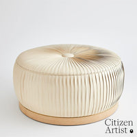 Colette Ottoman, shown in ivory and cream with fabric, wood, and fixed wood plinth base.
