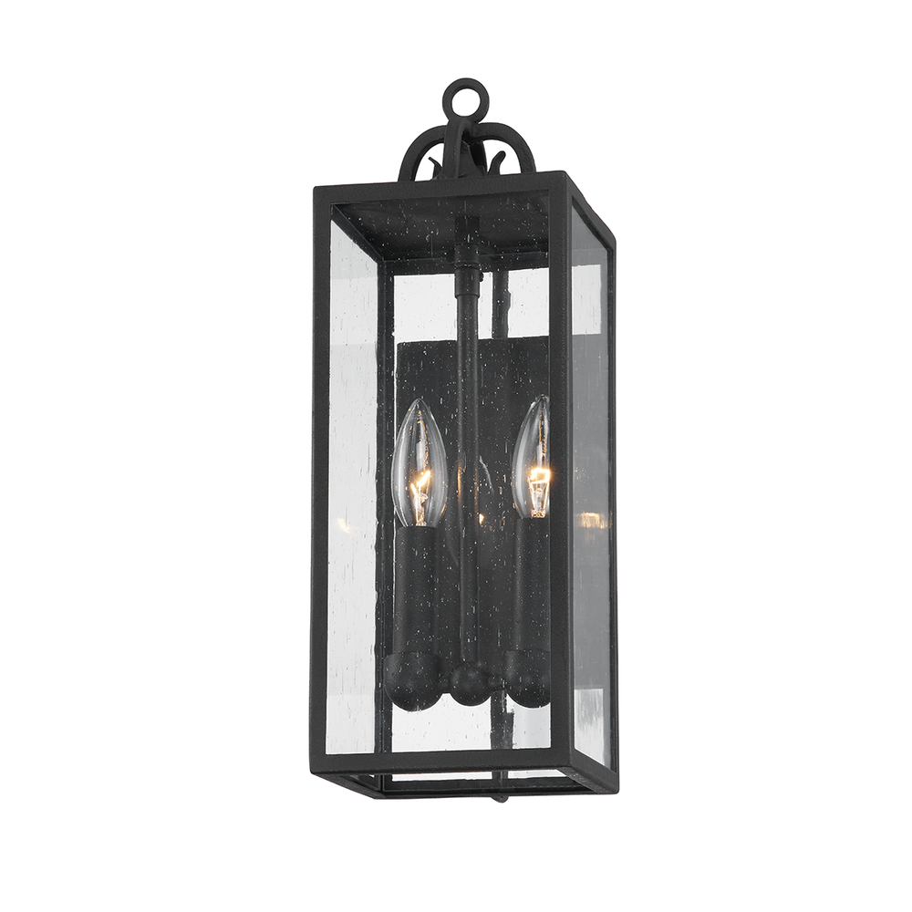 Caiden Wall Sconce, shown in black with forged iron, seeded glass, and a wall-mounting backplate.