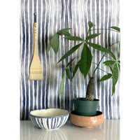 In Between Wallpaper, shown in blue and white with paper and wall-covering application.