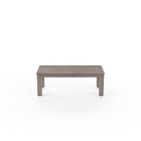 Laguna Outdoor Coffee Table, shown in warm gray and weathered taupe with wood or wood-look composite and slatted timber top.